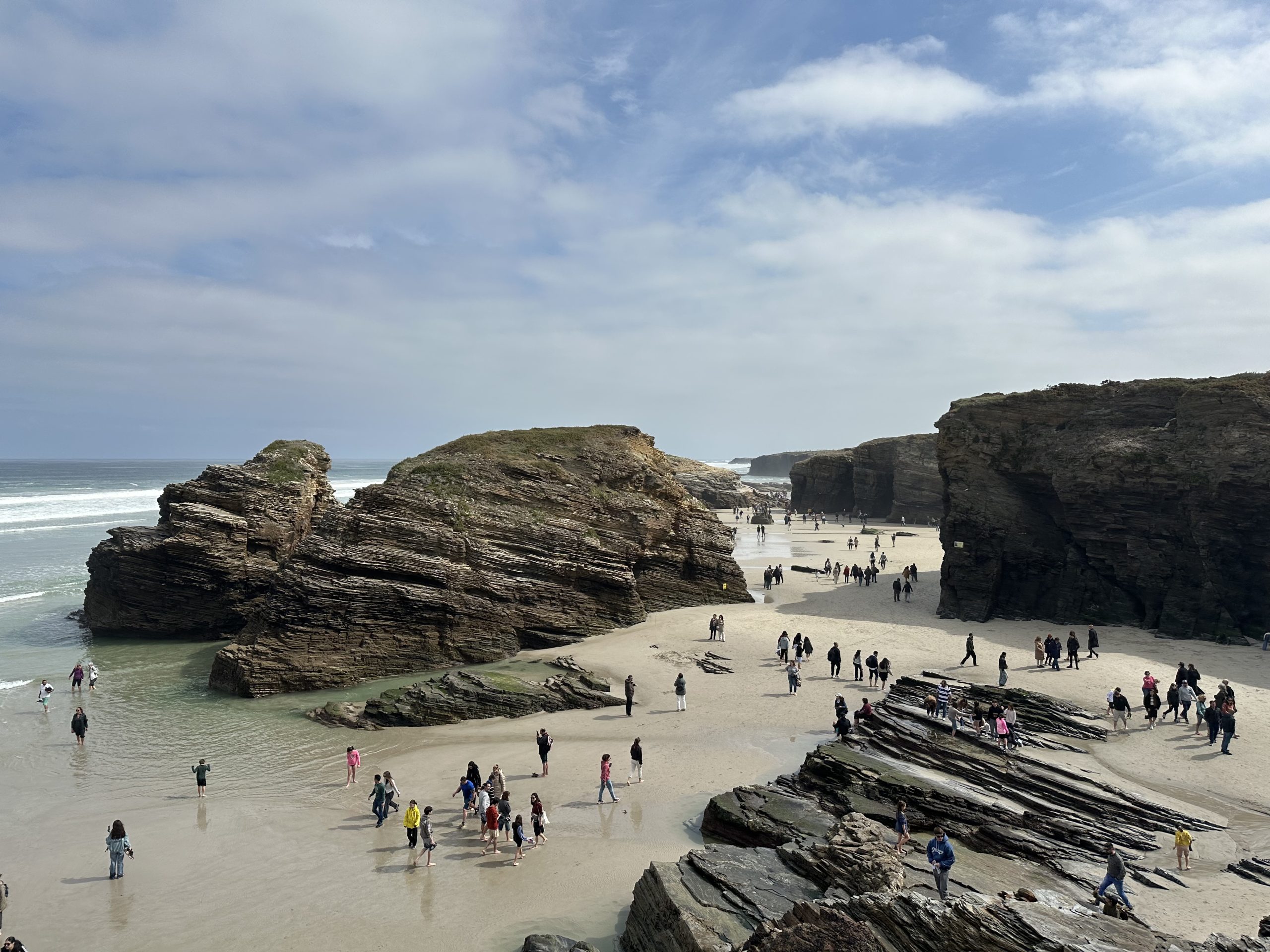 Vista panorámica de la Playa de las Catedrales con acantilados, rocas y visitantes en la arena