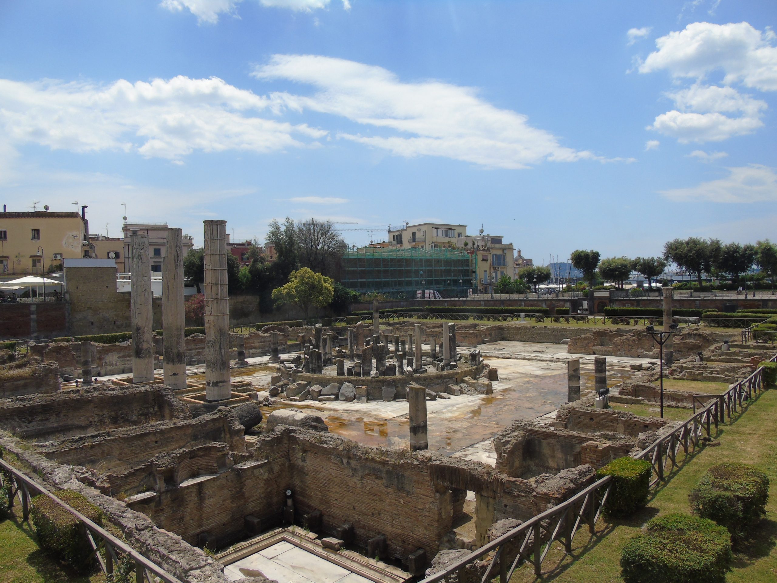 Ruinas arqueológicas en el centro de Nápoles con columnas y restos romanos.