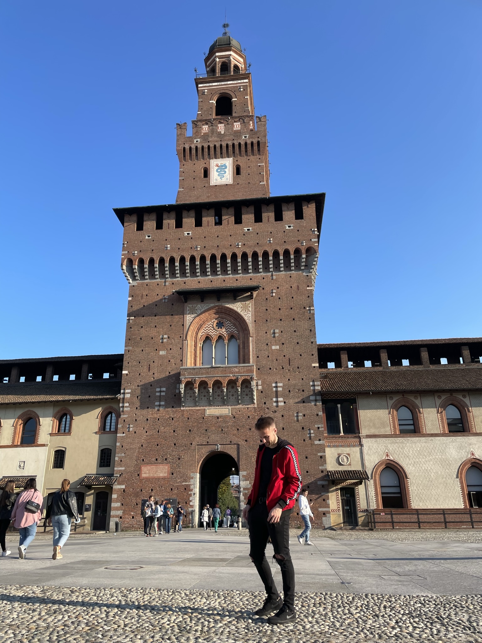Castillo Sforzesco de Milán con la Torre del Filarete y visitantes en la entrada principal
