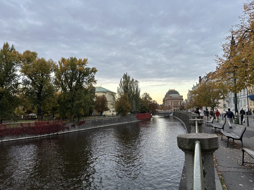 Paseo junto al río Moldava en Praga con vistas al Teatro Nacional y edificios históricos