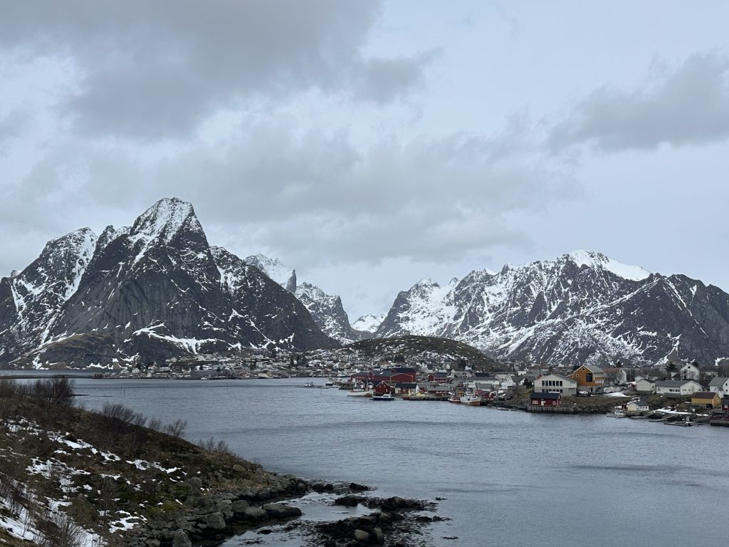 Montañas nevadas y pueblo de Reine junto al fiordo en las Islas Lofoten
