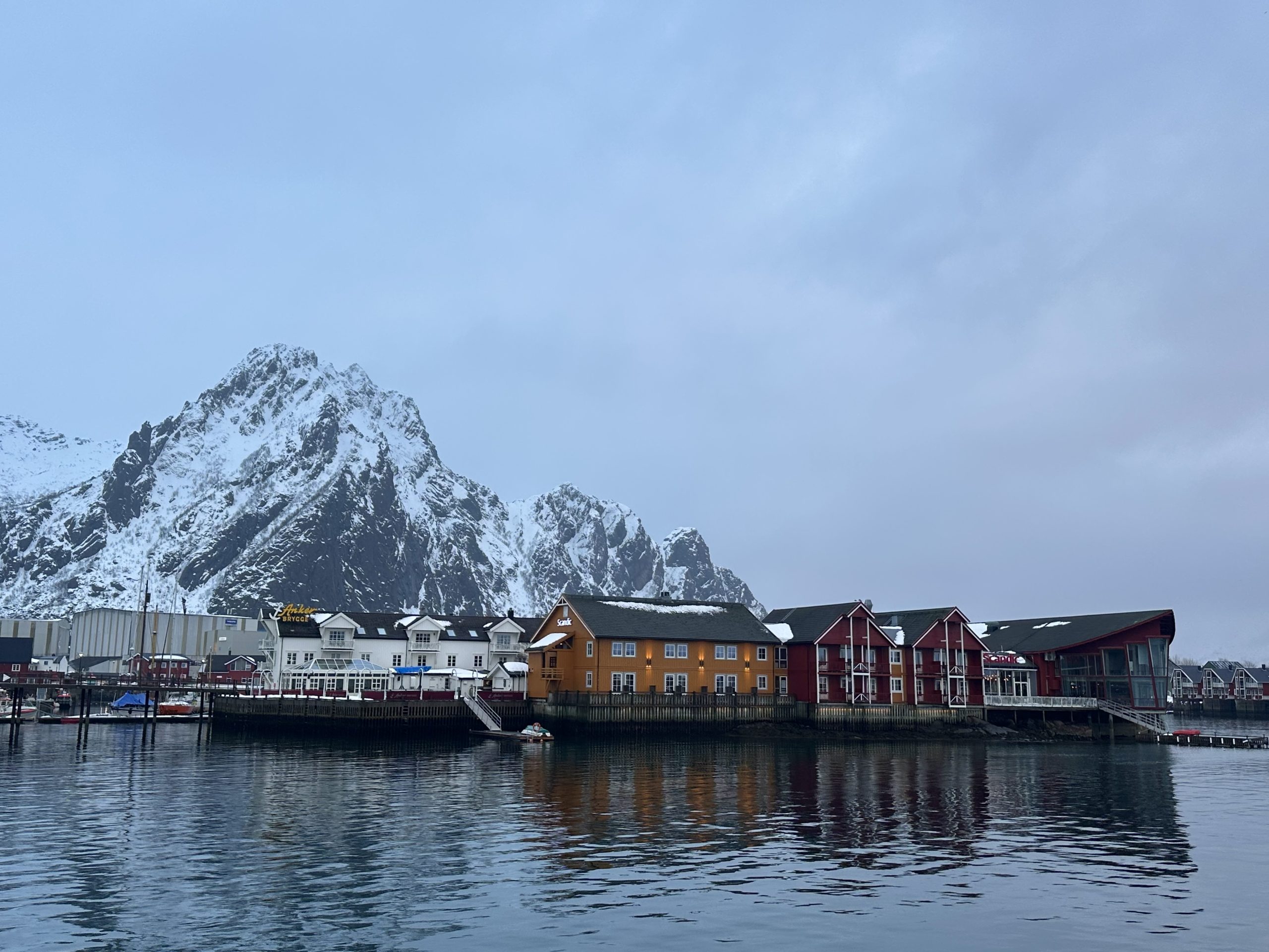Puerto de Svolvær con casas de colores y montañas nevadas en Lofoten