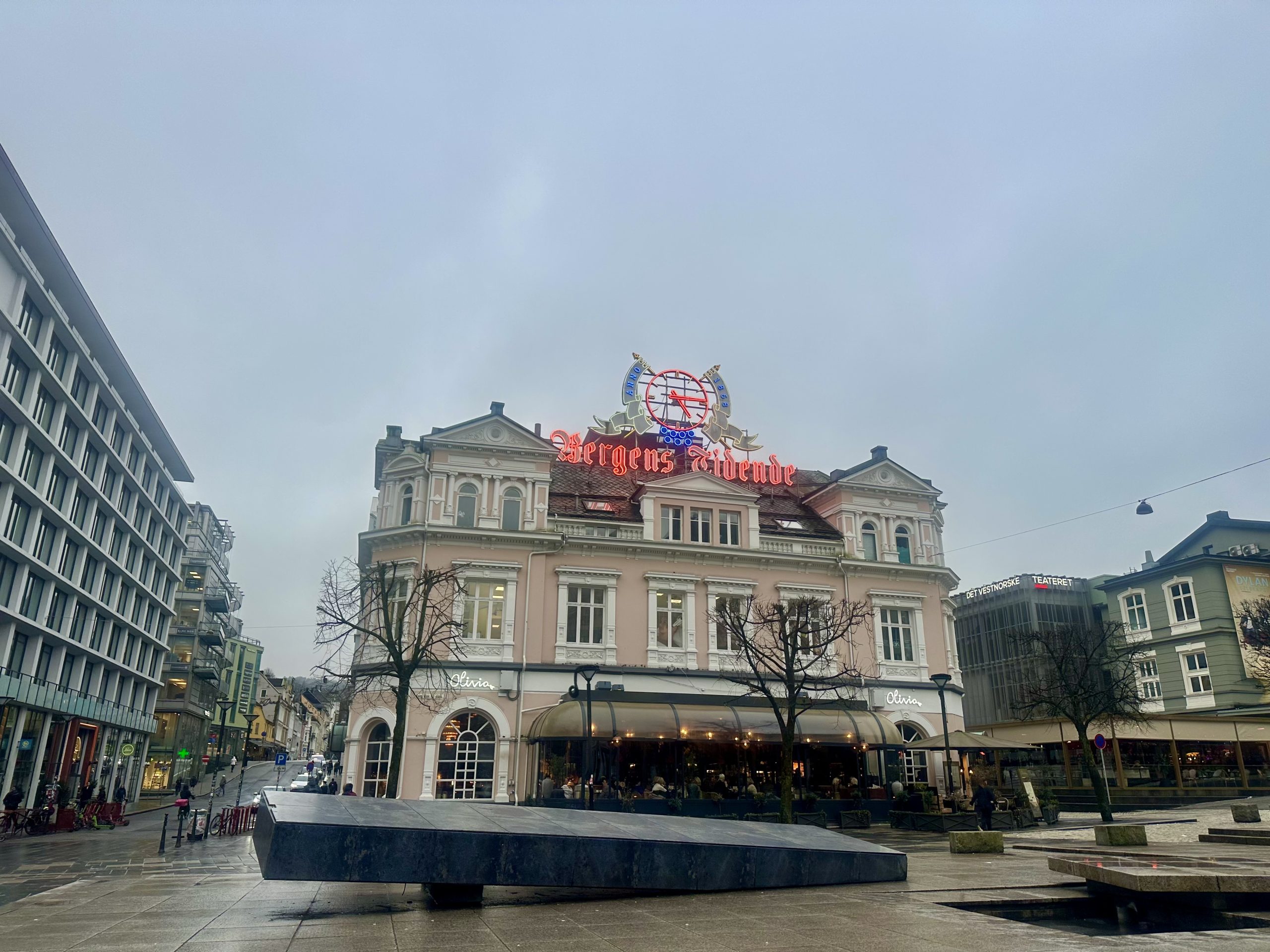Edificio histórico rosa con el cartel de Bergens Tidende en la plaza peatonal Torgallmenningen en Bergen, Noruega