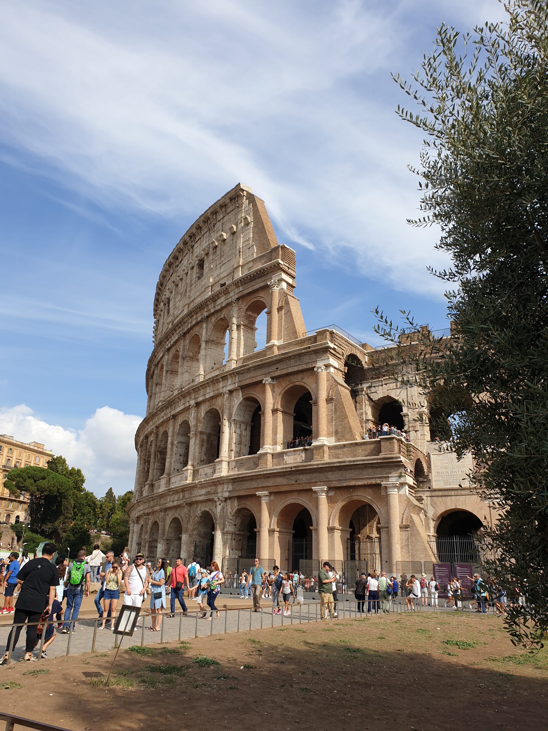 Exterior del Coliseo de Roma con visitantes junto al monumento.