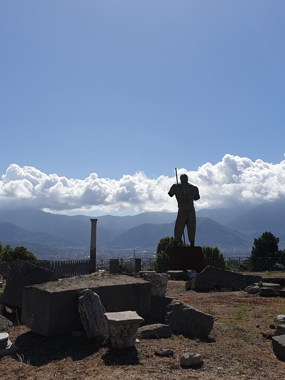 Estatua de Dédalo en Pompeya con las montañas al fondo.