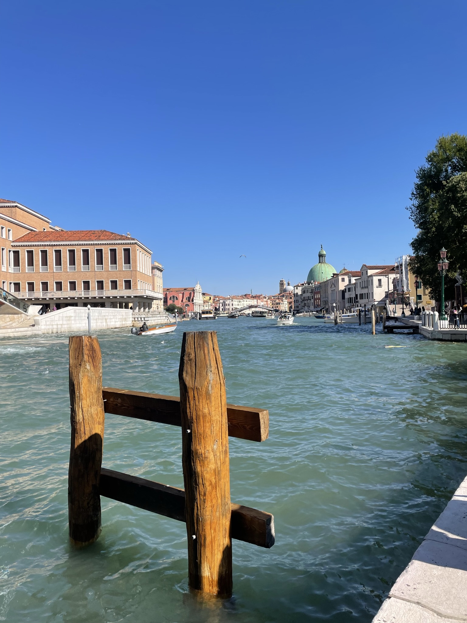 Vista del Gran Canal de Venecia con barcos, palacios históricos y la cúpula de San Simeone Piccolo al fondo.