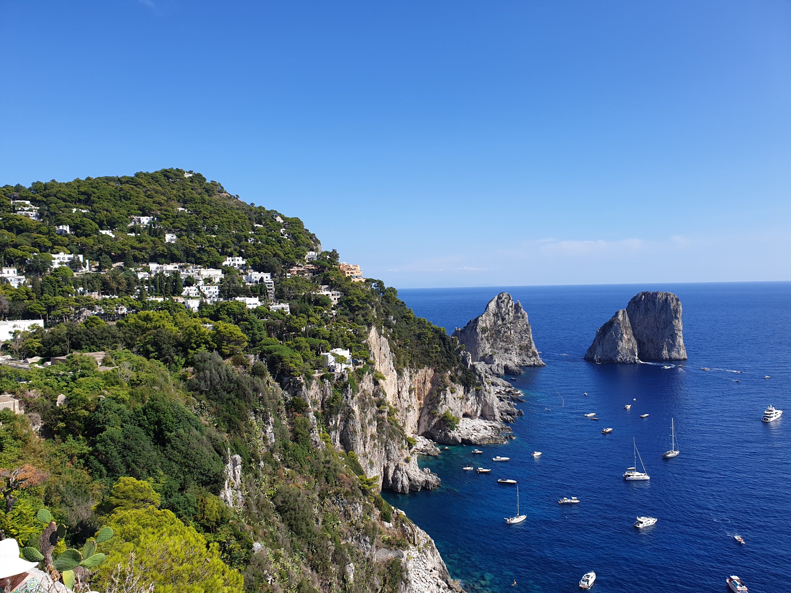 Mirador de Capri con vistas a los Faraglioni, acantilados y barcos sobre el mar azul
