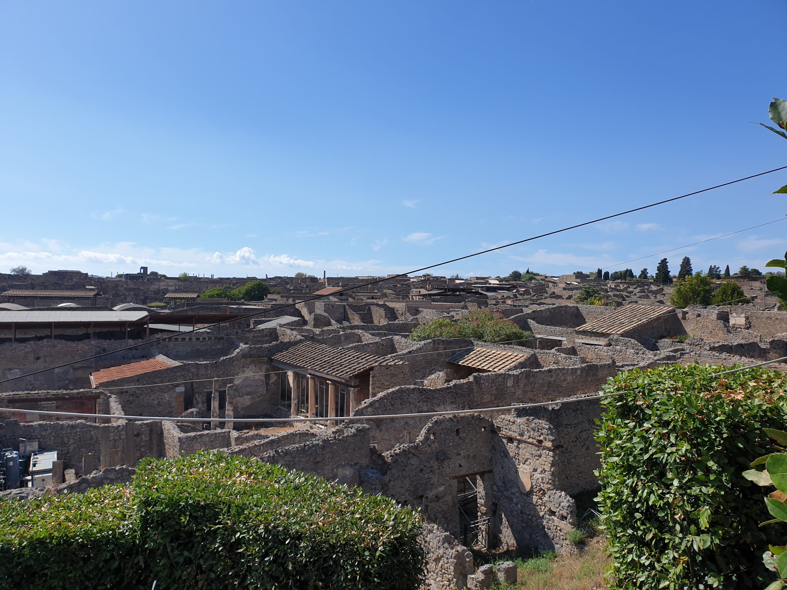 Vista general de las ruinas de Pompeya con antiguas casas romanas y tejados restaurados.