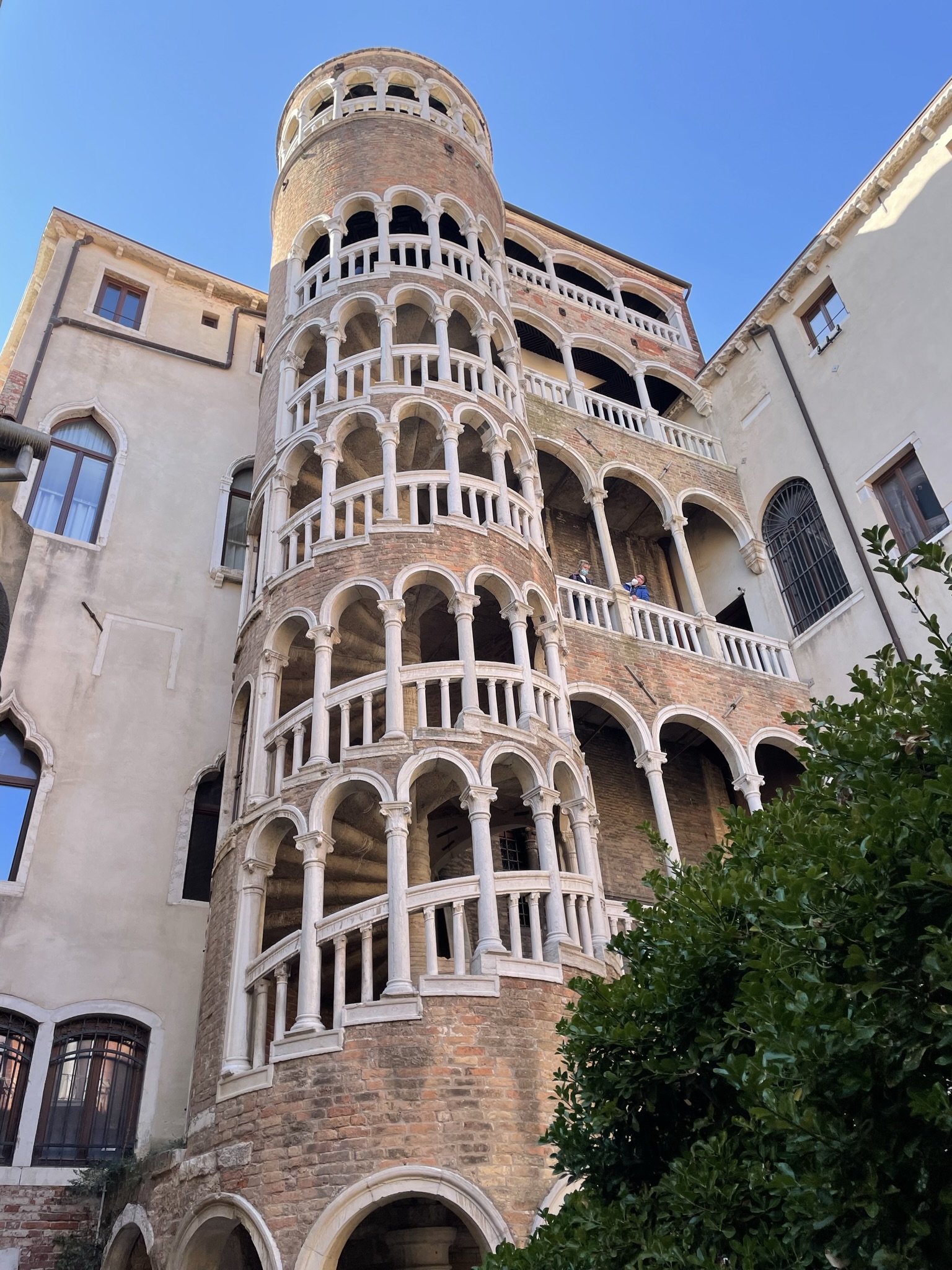 Escalera exterior del Palacio Contarini del Bovolo en Venecia, con arcos y estructura de ladrillo.