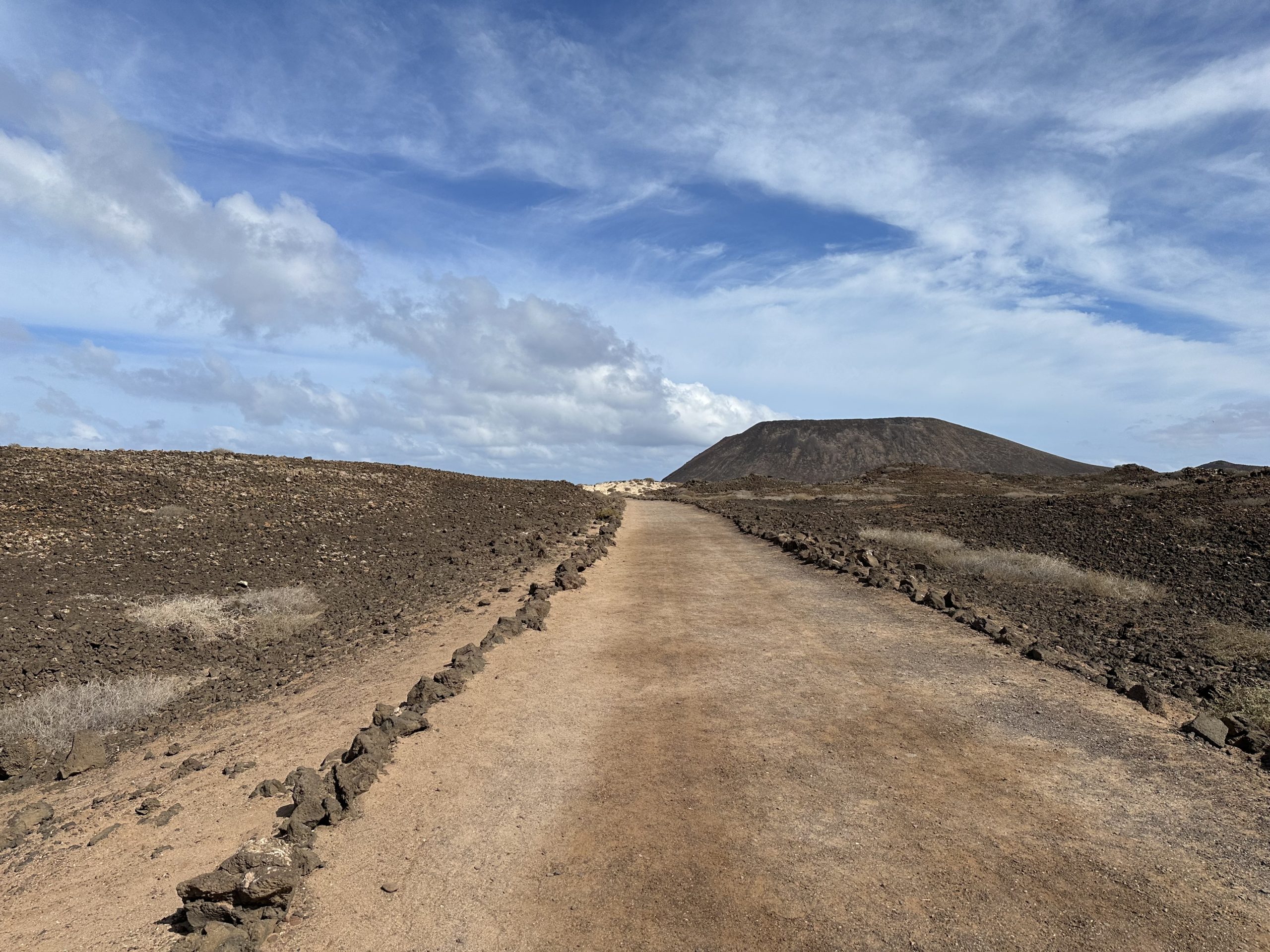 Sendero de la Isla de Lobos entre paisaje volcánico y vistas al mar en Fuerteventura