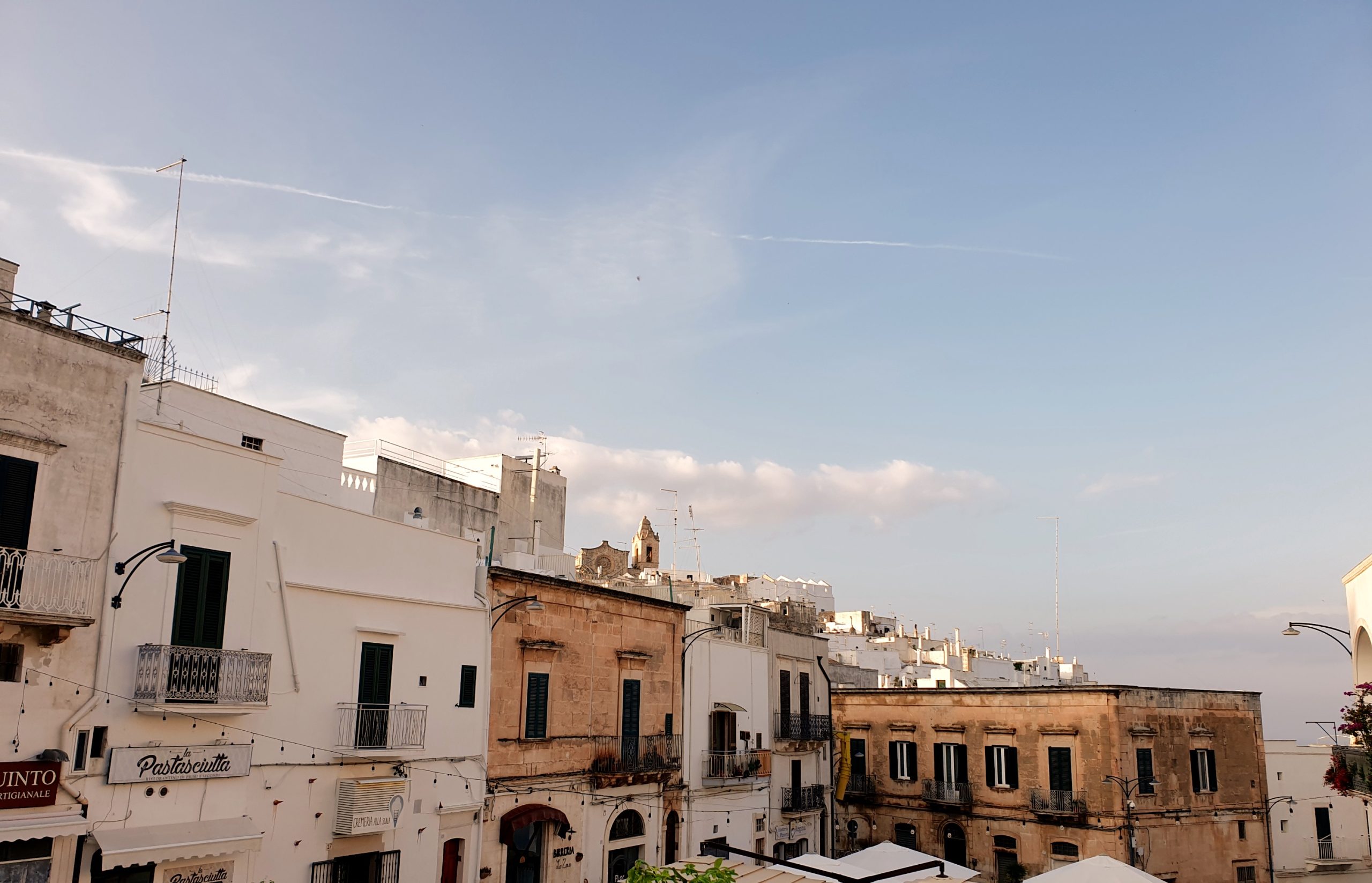 Vistas del centro histórico de Ostuni con casas blancas y edificios de piedra al atardecer.